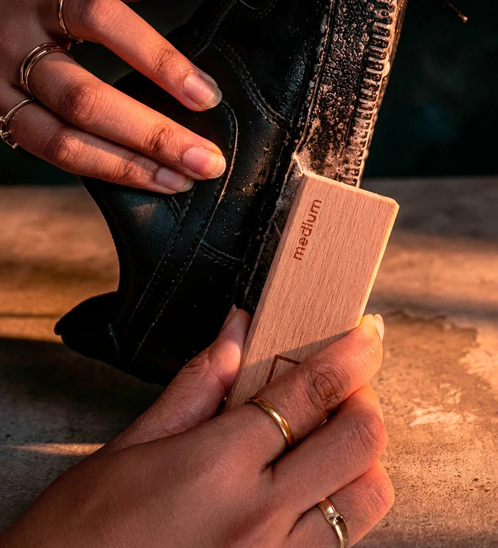 A man cleaning sneaker midsoles using SHOEGR Medium Brush