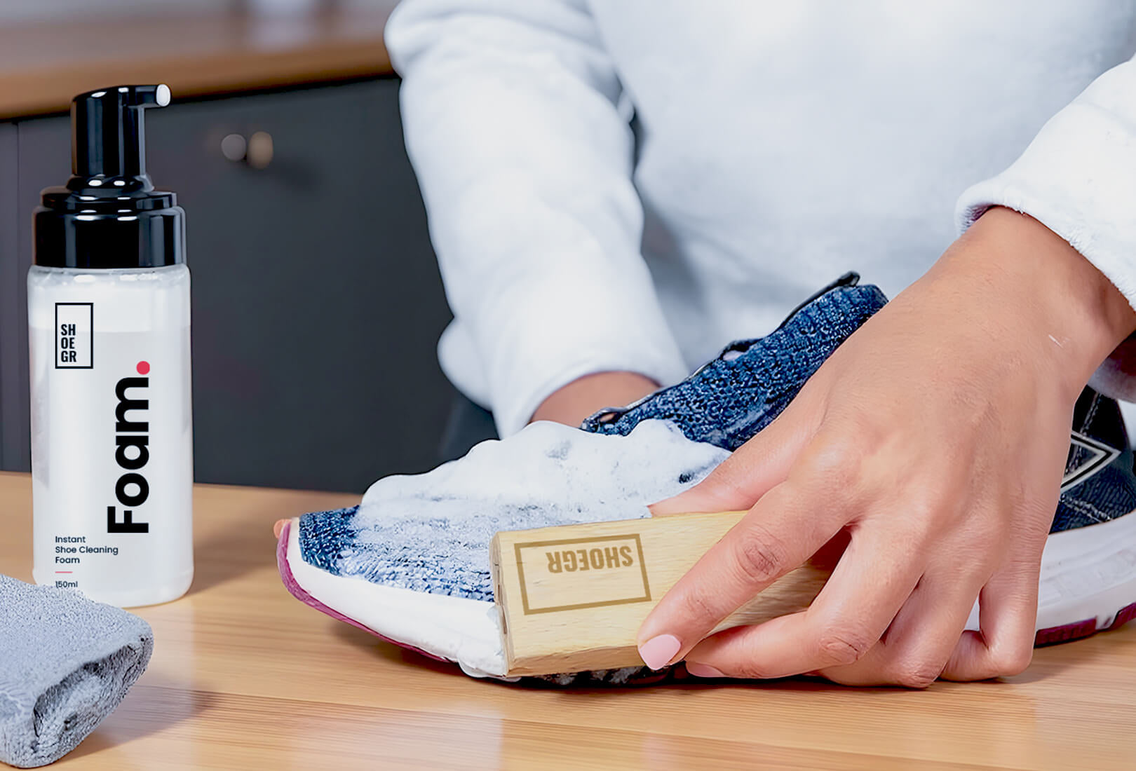 A person cleaning a knit shoe with SHOEGR Instant Pro Shoe Cleaning kit