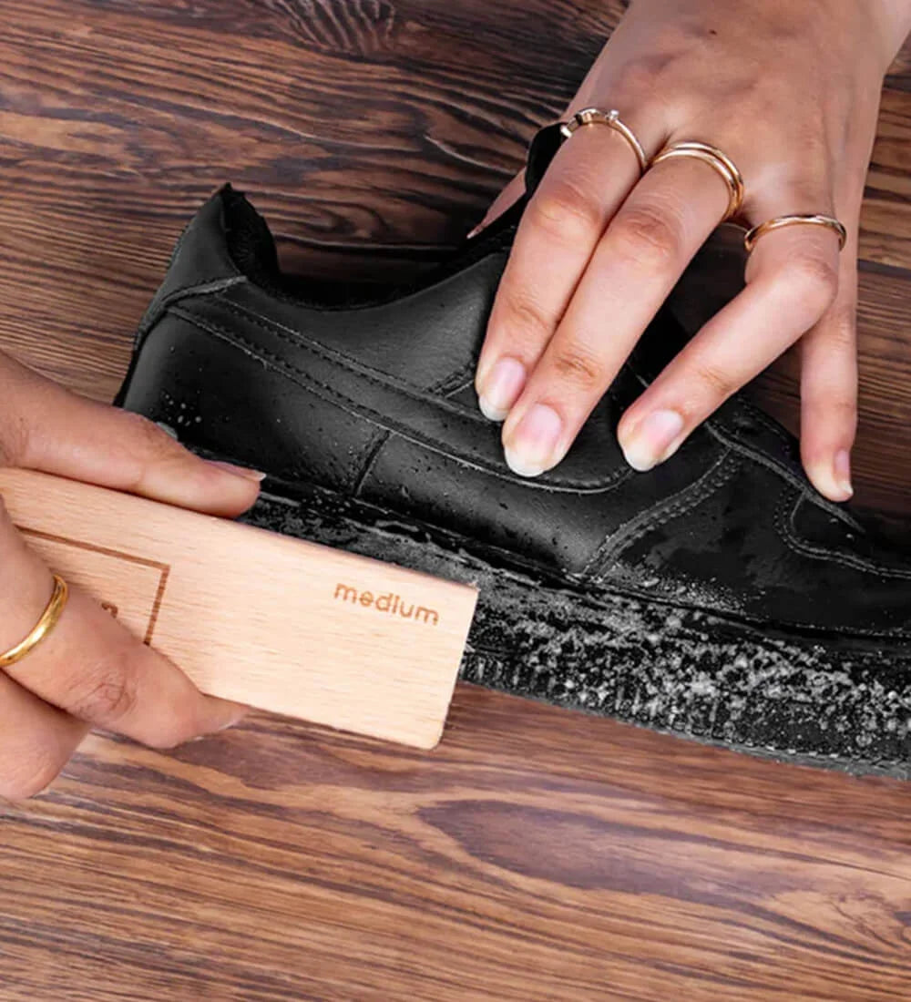Cleaning black sneaker midsole with SHOEGR medium brush